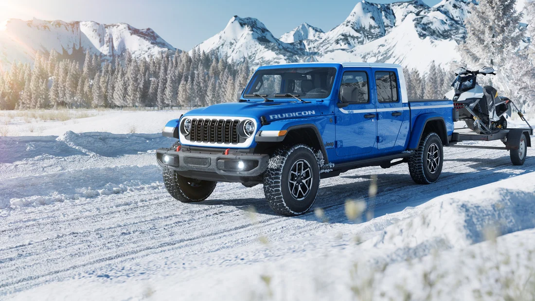 Jeep Gladiator truck equipped with winter tires traveling through Wyoming snowfall